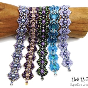 Könnte beinhalten: Sechs Perlenarmbänder in verschiedenen Schattierungen von Lila, Blau und Grün. Die Armbänder haben ein zartes Blumenmuster und sind auf einer Holzhand angeordnet.