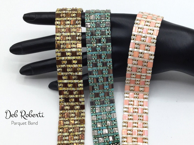 May include: Three beaded bracelets in a parquet pattern. The bracelets are brown and gold, teal and silver, and pink and gold.