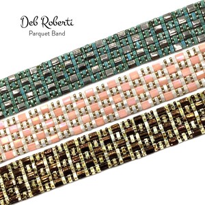 May include: Three beaded bracelets in different colors and patterns. The top bracelet is turquoise and silver, the middle bracelet is pink and white, and the bottom bracelet is brown and white. The bracelets are all made with small square beads and have a geometric pattern. The bracelets are labeled "Deb Roberti Parquet Band".