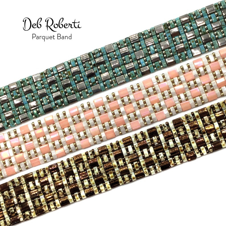 May include: Three beaded bracelets in different colors and patterns. The top bracelet is turquoise and silver, the middle bracelet is pink and white, and the bottom bracelet is brown and white. The bracelets are all made with small square beads and have a geometric pattern. The bracelets are labeled "Deb Roberti Parquet Band".