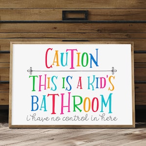 Könnte beinhalten: Ein weißes Schild mit dem Text "CAUTION THIS IS A KID'S BATHROOM i have no control in here" in bunten Buchstaben. Die Buchstaben sind in verschiedenen Farben, darunter Pink, Blau, Grün, Gelb und Orange.