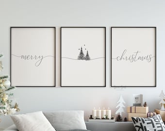 May include: Three vertical wall art prints in black frames featuring a minimalist design. The left print displays the word merry in black script, the center shows two pine trees with three dots, and the right print displays the word christmas.