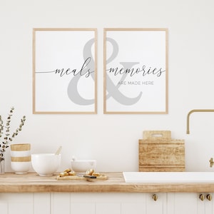 May include: Two framed prints with a gray ampersand symbol and the text "meals & memories are made here" in black script font.