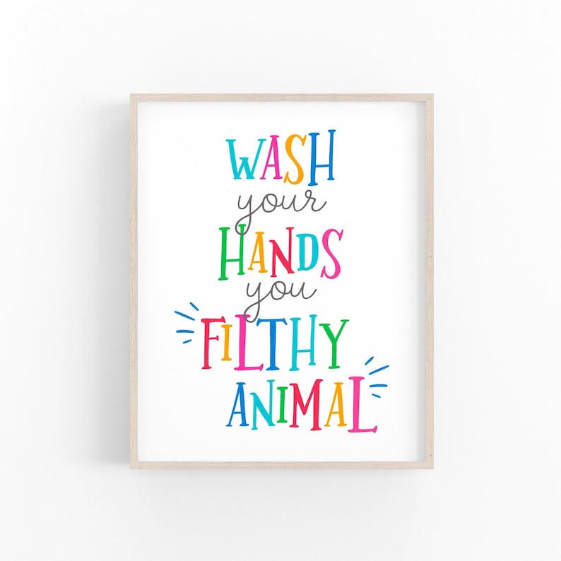 May include: A framed wall art print featuring the text WASH your HANDS you FILTHY ANIMAL in a variety of bright, multicolored letters. The words are arranged in a vertical layout with decorative lines accenting the text on a white background.
