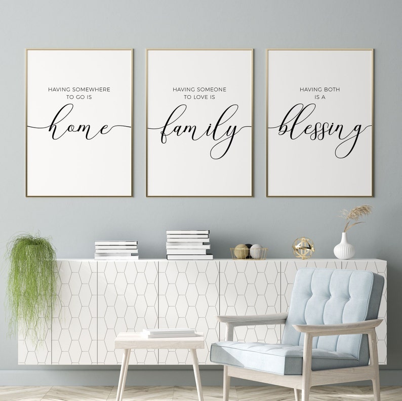 May include: Three framed prints with white backgrounds and gold frames. The prints feature black calligraphy text that reads "Having somewhere to go is home", "Having someone to love is family", and "Having both is a blessing".