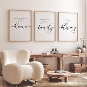 May include: Three framed prints with white backgrounds and black text. The first print says "Having somewhere to go is home". The second print says "Having someone to love is family". The third print says "Having both is a blessing".