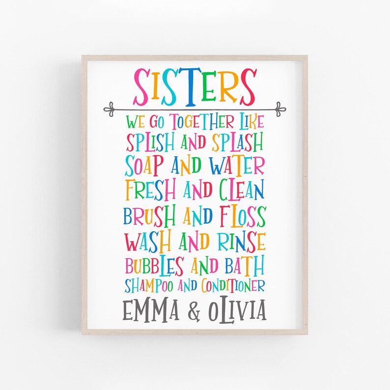 May include: A colorful printable wall art design with the text "SISTERS" in a rainbow of colors. The text reads "We go together like..." and lists pairs of words like "Splish and Splash", "Soap and Water", "Fresh and Clean", "Brush and Floss", "Wash and Rinse", "Bubbles and Bath", "Shampoo and Conditioner". The design is personalized with the names "Emma & Olivia".