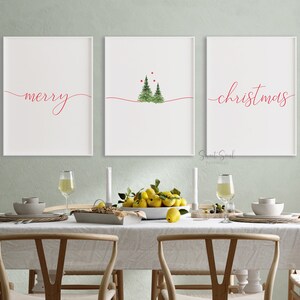May include: Three white framed prints with red text on a white background. The left print says "merry" in cursive. The middle print has a watercolor illustration of three green Christmas trees with red berries. The right print says "christmas" in cursive.
