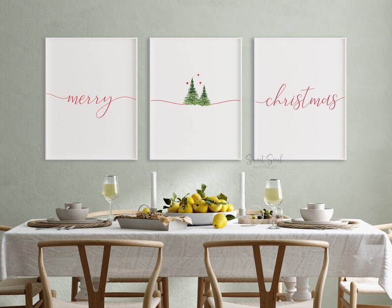 May include: Three white framed prints with red text on a white background. The left print says "merry" in cursive. The middle print has a watercolor illustration of three green Christmas trees with red berries. The right print says "christmas" in cursive.