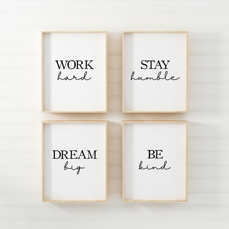 May include: Four framed prints with inspirational quotes: "WORK hard," "STAY humble," "DREAM big," and "BE kind." Each print has a white background with black text in a mix of fonts, set in light wood frames.