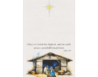 May include: A rectangular, off-white towel featuring a watercolor illustration of a nativity scene. The scene includes a wooden stable, figures, and text that reads "Glory to God in the highest, and on earth peace, goodwill toward men. Luke 2:14". A yellow star is at the top.