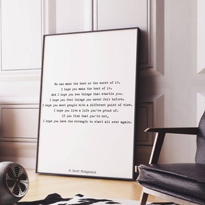 May include: A framed vertical wall art print featuring black typewriter-style text on a white background. The quote reads: We can make the best or the worst of it. I hope you make the best of it. F. Scott Fitzgerald is signed at the bottom.