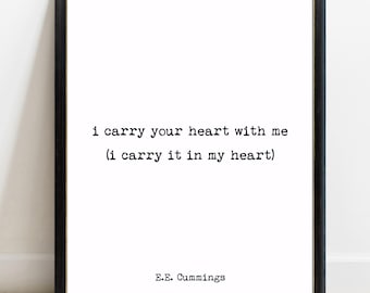 May include: A black framed wall art print featuring the E.E. Cummings quote i carry your heart with me (i carry it in my heart) in a black typewriter-style font on a white background. The author name E.E. Cummings is printed at the bottom.
