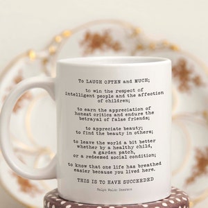 Puede incluir: Taza de cer&aacute;mica blanca con una cita negra de Ralph Waldo Emerson sobre el &eacute;xito. La cita dice: "Re&iacute;r a menudo y mucho; ganar el respeto de la gente inteligente y el afecto de los ni&ntilde;os; ganarse la apreciaci&oacute;n de los cr&iacute;ticos honestos y soportar la traici&oacute;n de los falsos amigos; apreciar la belleza; encontrar la belleza en los dem&aacute;s; dejar el mundo un poco mejor, ya sea por un ni&ntilde;o sano, un huerto o una condici&oacute;n social redimida; saber que una vida ha respirado m&aacute;s f&aacute;cilmente porque has vivido aqu&iacute;. Esto es haber tenido &eacute;xito."
