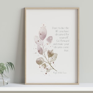 May include: A framed print with a watercolor painting of a leafy branch with pink and brown leaves. The print has a quote that reads 'Dare to live the life you have dreamed for yourself. Go forward and make your dreams come true.' The quote is attributed to Ralph Waldo Emerson.