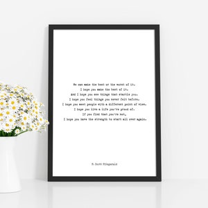 May include: A black framed wall art print featuring a F. Scott Fitzgerald quote in a typewriter-style font on a white background. The text reads: We can make the best or the worst of it. I hope you make the best of it. I hope you have the strength.