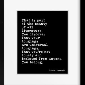 May include: A framed wall art print featuring a black background with white typewriter-style text that reads: That is part of the beauty of all literature. You discover that your longings are universal longings, that you're not lonely and isolated from anyone. You belong. f scott fitzgerald.