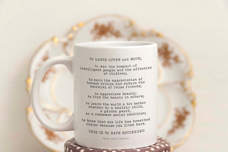 Puede incluir: Taza de cer&aacute;mica blanca con una cita negra de Ralph Waldo Emerson sobre el &eacute;xito. La cita dice: "Re&iacute;r a menudo y mucho; ganar el respeto de la gente inteligente y el afecto de los ni&ntilde;os; ganarse la apreciaci&oacute;n de los cr&iacute;ticos honestos y soportar la traici&oacute;n de los falsos amigos; apreciar la belleza; encontrar la belleza en los dem&aacute;s; dejar el mundo un poco mejor, ya sea por un ni&ntilde;o sano, un huerto o una condici&oacute;n social redimida; saber que una vida ha respirado m&aacute;s f&aacute;cilmente porque has vivido aqu&iacute;. Esto es haber tenido &eacute;xito."