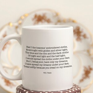 May include: White ceramic mug with a black quote by W.B. Yeats: "Had I the heavens' embroidered cloths, Enwrought with golden and silver light, The blue and the dim and the dark cloths Of night and light and the half light, I would spread the cloths under your feet: But I, being poor, have only my dreams; I have spread my dreams under your feet: Tread softly because you tread on my dreams."