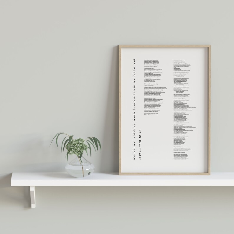 May include: A framed print of a poem titled "The Love Songs of J. Alfred Prufrock" by T.S. Eliot. The print is hanging on a white shelf with a small vase of greenery in front of it.