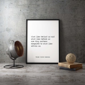 May include: A black framed print with a white background and a quote by Ralph Waldo Emerson: "What lies behind us and what lies before us are tiny matters compared to what lies within us."