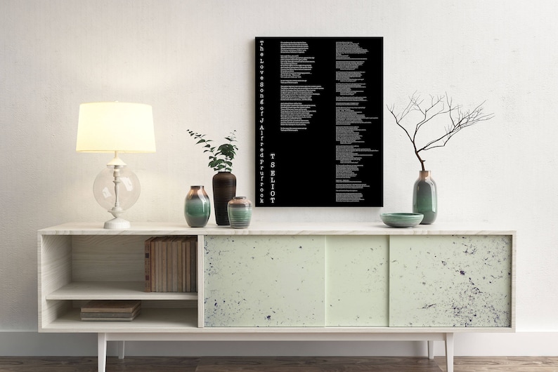 May include: A white lamp with a white shade sits on a white and green cabinet with a black and white poster that reads "The Love Song of J. Alfred Prufrock" by T.S. Eliot. There are three vases on the cabinet, one green, one brown, and one white.