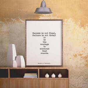 May include: A framed print with a motivational quote by Winston S. Churchill: "Success is not final, failure is not fatal: it is the courage to continue that counts."