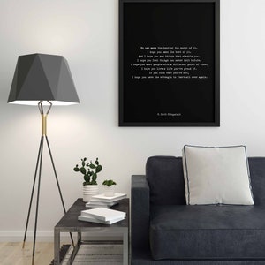 May include: A black framed wall art print featuring white typewriter-style text of a quote by F. Scott Fitzgerald. The text reads: We can make the best or the worst of it. I hope you make the best of it. And I hope you see things that startle you.