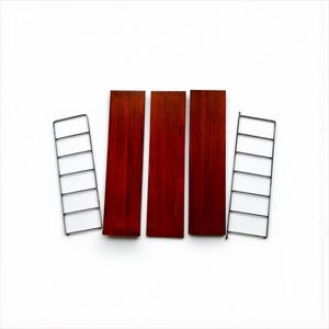 May include: A set of three rectangular, reddish-brown wooden shelves with a dark, rich grain. Two black metal wire frames are positioned on either side, designed to hold the shelves. The components are arranged on a white background.