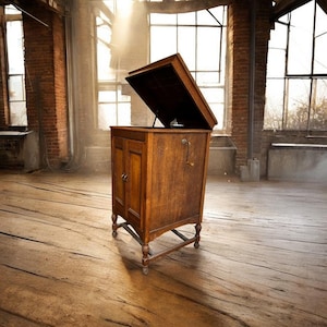 May include: A classic wooden gramophone with the lid raised, showcasing its internal components. The cabinet is a rich brown hue, featuring two doors and decorative legs. The gramophone is positioned in a rustic, sunlit room with exposed brickwork and wooden flooring.