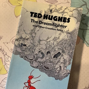 May include: A book cover with a blue background and a red ant on a rock. The book title is "The Dreamfighter and Other Creation Tales" by Ted Hughes.