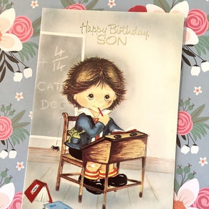 Cartão vintage raro de 'Feliz Aniversário, filho' da década de 1970 - Design retrô kitsch fofo de um estudante de aparência 'desleixada' sentado em sua mesa - Fofo