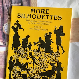 May include: A yellow book cover with the title "MORE SILHOUETTES" and the text "868 Copyright-Free Illustrations for Artists and Craftsmen. Edited by Carol Belanger Grafton". The cover features black silhouettes of people in various poses.