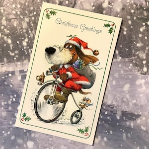 RARE carte vierge vintage des années 1970 « Christmas Greetings » avec un chien SUPER rétro déguisé en père Noël à vélo par John Patience