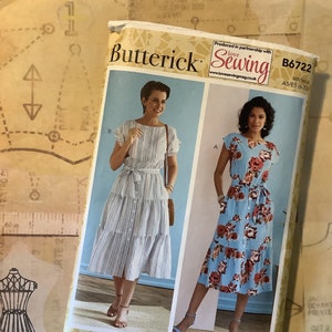 May include: A sewing pattern for a dress with two different styles. The pattern is from Butterick and is for sizes 6-22. The dress on the left is a striped dress with a button-down front and a tie belt. The dress on the right is a floral print dress with a tie belt. The pattern is called "Love Sewing" and is produced in partnership with Love Sewing Magazine.