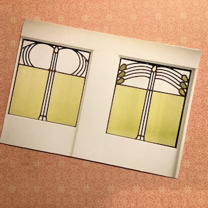 May include: Two white framed stained glass windows with a geometric design. The top window has a curved design with a central vertical line. The bottom window has a curved design with a central vertical line and a horizontal line across the middle.