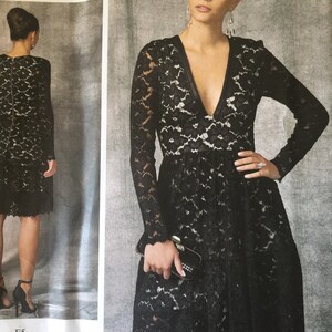 Pu&ograve; includere: Un abito nero in pizzo con scollo a V profondo e maniche lunghe. L'abito ha un corpetto aderente e una gonna svasata. L'abito &egrave; mostrato su una modella con una pochette.