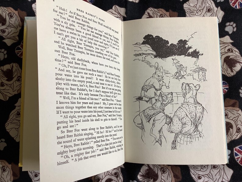 May include: An open book with illustrations and text. The left page has text, while the right page features a black and white drawing of anthropomorphic animals. The book is titled "Brer Rabbit's Pond".