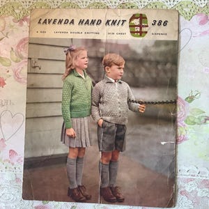 May include: Vintage "Lavenda Hand Knit" pattern booklet featuring two children in knitted sweaters and shorts. The cover shows a girl in a green zip-up sweater and a boy in a striped sweater. The booklet is aged with visible wear.