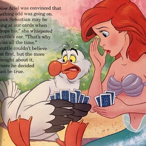 Pu&ograve; includere: Ariel, una sirena con lunghi capelli rossi, sussurra a Scuttle, un uccello bianco con un grande becco arancione, mentre giocano a carte. Scuttle sembra sorpreso e tiene un mazzo di carte nelle sue zampe palmate. Il testo dice: "Ora Ariel era convinta che stesse succedendo qualcosa di strano. "Penso che Sebastian possa guardare le nostre carte quando lascia cadere le sue," sussurr&ograve; all'orecchio di Scuttle. "Ecco perch&eacute; vince sempre." Scuttle non riusciva a crederle all'inizio, ma pi&ugrave; ci pensava, pi&ugrave; si convinceva che doveva essere vero."