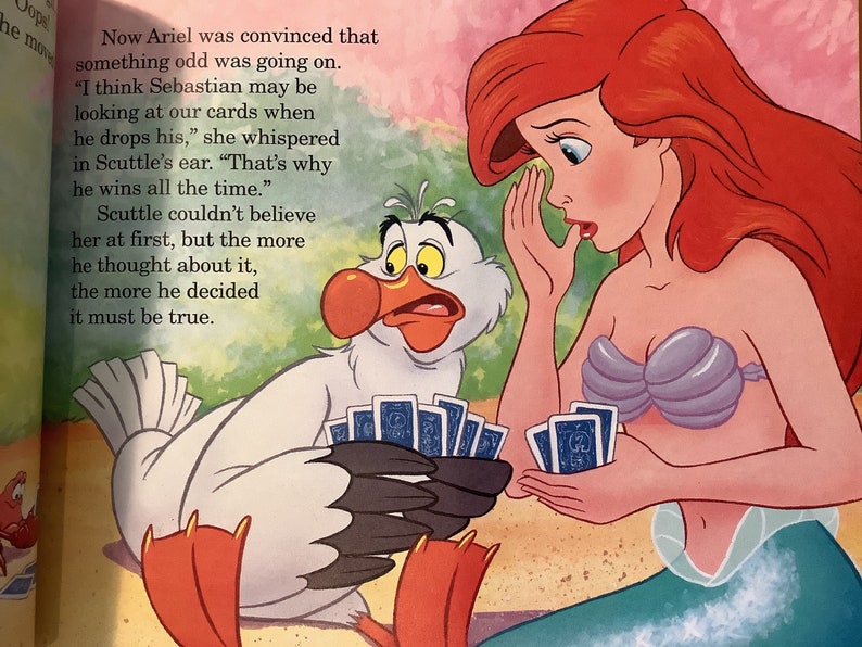 Pu&ograve; includere: Ariel, una sirena con lunghi capelli rossi, sussurra a Scuttle, un uccello bianco con un grande becco arancione, mentre giocano a carte. Scuttle sembra sorpreso e tiene un mazzo di carte nelle sue zampe palmate. Il testo dice: "Ora Ariel era convinta che stesse succedendo qualcosa di strano. "Penso che Sebastian possa guardare le nostre carte quando lascia cadere le sue," sussurr&ograve; all'orecchio di Scuttle. "Ecco perch&eacute; vince sempre." Scuttle non riusciva a crederle all'inizio, ma pi&ugrave; ci pensava, pi&ugrave; si convinceva che doveva essere vero."