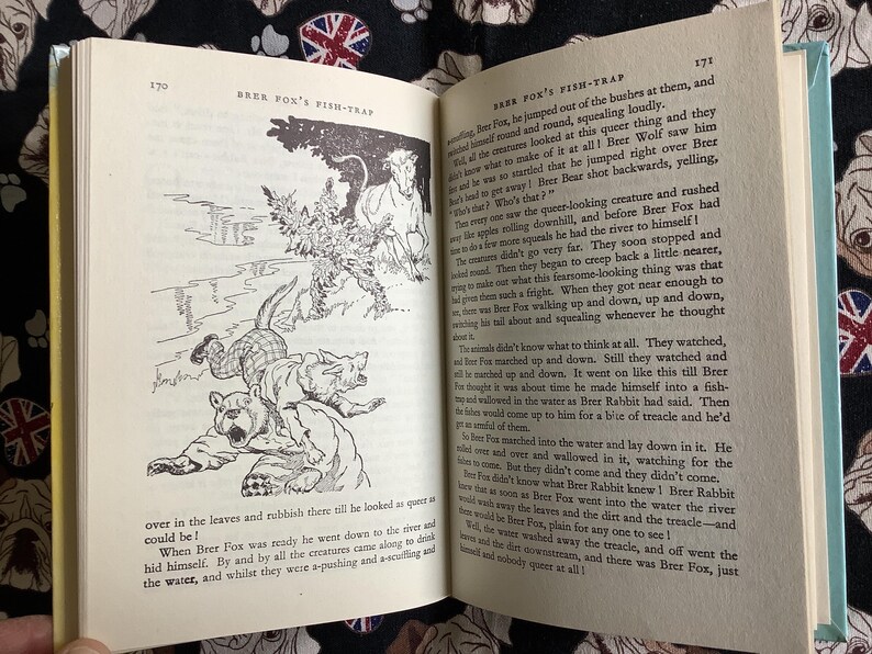 May include: Open book with illustrations and text. The left page features a black and white drawing of animals and a river scene. The right page has text. The book is open to pages 170 and 171, with the title "BRER FOX'S FISH-TRAP".
