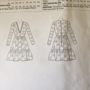 Pu&ograve; includere: Un disegno in bianco e nero di un modello di vestito con istruzioni per le taglie 6-22. Il modello include le misure per l'abito e il tessuto necessario. Il testo nell'immagine dice: "Series: A5(6-8-10-12-14), E5(14-16-18-20-22)  TISSUS: Extensibles dans les deux sens: Dentelle extensible &agrave; bord festonn&eacute;. Triplure/doublure: Tricot. "Avec Sens.  TAILLES  ROBE  150cm*  6 8 10 12 14 16 18 20 22  3.5 3.6 3.6 3.6 3.7 3.8 3.9 3.9 4.0  TRIPLURE/DOUBLURE  150cm*  2.0 2.0 2.0 2.0 2.0 2.3 2.3 2.3 2.4  MERCERIE: Fermeture &agrave; Glissi&egrave;re de m&eacute;tal de 55cm, 1.0m de Ruban gros-grain de 2.2cm."