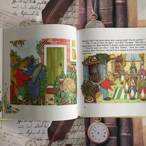Op de afbeelding: Een illustratie uit een kinderboek met een groep konijnen die rond een open haard staan. De tekst luidt: "Mister Lion's just gone along here, roaring mad! You be careful!" "Oh, I can do that all right," said Brer Terrapin. "But why am I to shout that out, Brer Rabbit? It doesn't make any kind of sense to me." "You'll soon see why," said Brer Rabbit. "And you come in this evening, Brer Terrapin, and we'll have supper in my house and a bit of a sing-song."