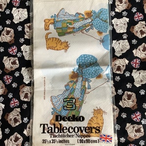 May include: A pack of 3 Deeko tablecloths featuring a vintage illustration of two girls and a cat. The tablecloths are 35 1/2 inches by 35 1/2 inches (90 x 90 cm).