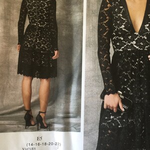 Pu&ograve; includere: Un abito nero in pizzo con scollo a V e maniche lunghe. L'abito ha un corpetto aderente e una gonna svasata. L'abito &egrave; mostrato su una modella con una pochette nera.