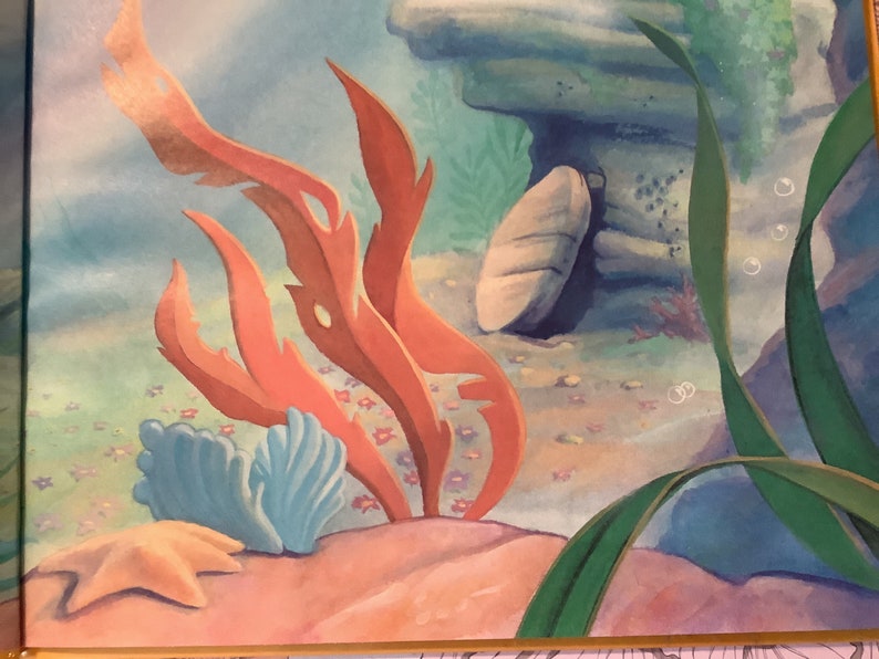 Pu&ograve; includere: Una scena sottomarina con una grande formazione rocciosa, alghe rosse e una stella marina sul fondo dell'oceano. La scena &egrave; dipinta in uno stile fantasioso con colori tenui.