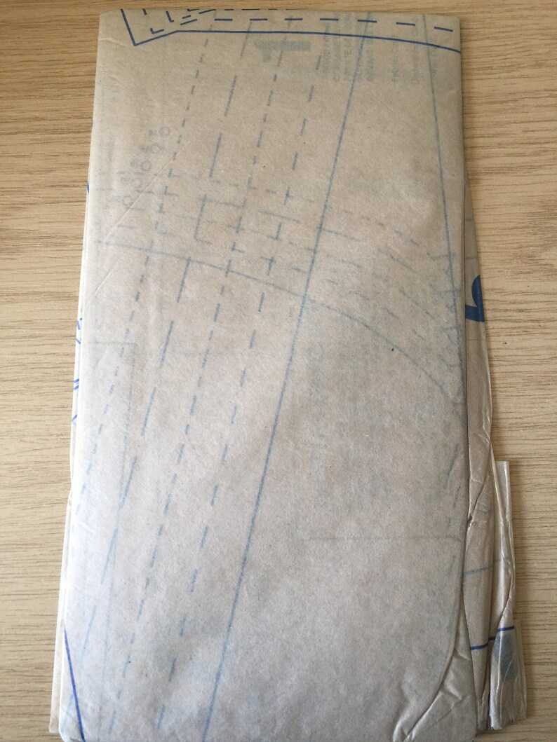 Pu&ograve; includere: Un foglio di cartamodello marrone con linee e segni blu.