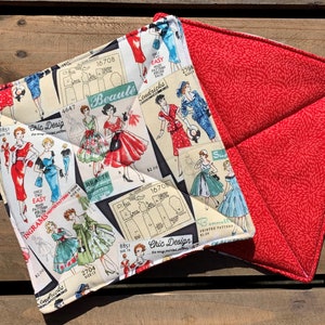 May include: Two red and white quilted pot holders. One side features a vintage pattern of women's fashion illustrations with the text "Cric Design" and "Beauté". The other side is a solid red with a white floral pattern.