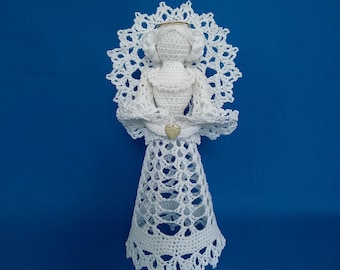 May include: White crocheted angel ornament with a gold halo and a heart-shaped embellishment. The angel is standing on a blue background.